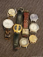 All 8 Fossil brand watches arranged on a fabric surface, showing variety of bands and dials