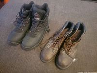 Two pairs of men's boots placed side by side on a carpeted floor.