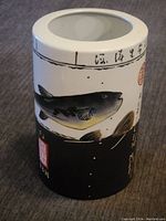 Front view of ceramic vase showing detailed hand-painted fish.