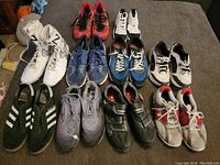 Overview of all eleven pairs of athletic shoes displayed on a grey surface