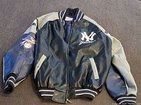 Front view of the black and gray leather jacket showing New York Yankees logo and design details.