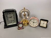 Wide view showing all clocks arranged in a row on a white surface.