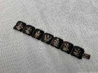 Full length photo of the 7-panel sterling silver bracelet featuring engraved Thai goddess dancers.