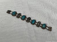 Full view of the 7 inch Egyptian sterling silver bracelet featuring turquoise scarab beetles and hieroglyphic silver plaques.