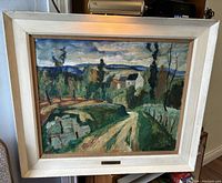 Full view of painting in painted wooden frame propped on furniture