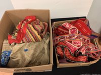 Two boxes containing folded vintage textiles showing varied colorful and geometric patterns