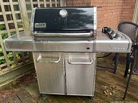 Full view of grill showing hood, cabinet base and side shelves