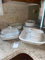 Photo showing Pyrex CorningWare casserole dishes and bowls on countertop, including glass lids and floral baking dish
