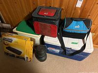 Full view of lot items: coolers, cooler bags, lantern, and boxed air mattress.