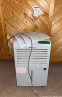 Front view of the white Danby Premiere dehumidifier showing air vents, power cord, and some dirt on surface.