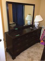 Full view of dresser with mirror on top against wall