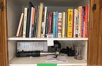 Cookbooks on another shelf including Mennonite Community Cookbook, Food That Really Schmecks, and The Pleasures Processor showing more cookbook variety and some spiral bound editions.