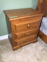 Front view of solid pine nightstand showing three drawers