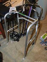 Photo of full lot showing aluminum walker with front wheels, canes, metal rack, grabber tool, and bed safety rail assembled together.