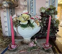 Porcelain floral centerpiece with candle holders and grape vine decor arranged on table