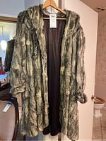 Full view of the beaver fur coat hanging, showing the length and overall design.
