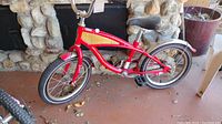 Side view of the red Kid's Schwinn Smart Start bike showing frame, wheels, pedals, and seat.
