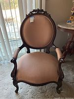 Salon chair with carved wood frame and reddish-brown striped upholstery
