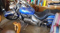 Left side view of blue cruiser motorcycle parked in garage