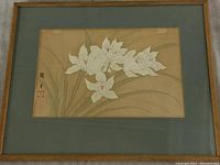 Full view of framed watercolour painting showing white flowers and green leaves on brown background with Asian signature and red seal.