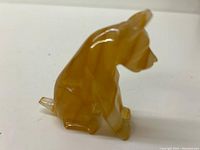 Side view of the handcrafted onyx dog figurine showing smooth polished surface and yellow-brown stone pattern.
