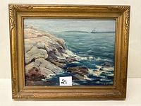 Full view of framed seascape showing rocky shoreline, ocean waves, and distant ship