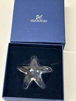Clear faceted crystal starfish in original blue Swarovski box with black velvet-like insert and Swarovski logo on lid.