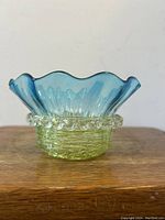 Front view of the finger bowl showing green threaded base and blue ruffled top.