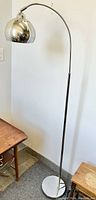 Full view of chrome arc floor lamp showing height and structure