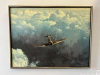 Framed canvas art print displaying "Evening Flight" featuring a WWII Spitfire airplane flying in cloudy skies, signed by Gerald Coulson.