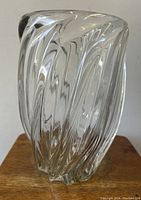 Full side view of the clear crystal vase showing the swirling waterfall design pattern and solid thick glass.