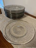 Stack of 12 silver rimmed etched glass salad plates with one plate laid flat showing etched design
