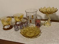 Group image showing all items: amber glass tumblers, clear glass vase, purple leaf shot glasses, leather wrapped shot glass, amber glass candy dish.