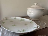 Shows oval floral Limoges platter, white ceramic soup terrine, and clear crystal leaf dish together