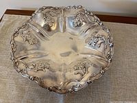 Top view showing the full scalloped rim of the silver plated bowl with floral and vine embossed decoration.