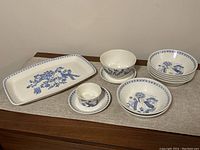Wide shot of entire set on table, showing arrangement of plates, bowls, tray, and cups.