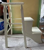 Side view of the vintage wooden stool showing the legs and the flipped out step portion.