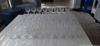 Full set of crystal glassware showing rows of various stemmed and non-stemmed glasses.