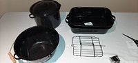 Overview of all cookware items: roasting pan with rack, 13" pot without lid, 11" pot with lid