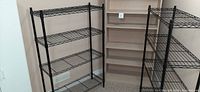 Photo showing two black metal wire shelving units side by side with one fully assembled.