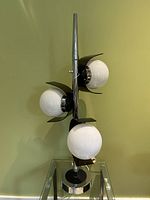 Front view of lamp showing lamp body, base, and three lucite shades
