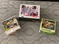 Three boxed jigsaw puzzles grouped together, showing all puzzle names and piece counts.