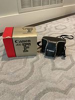 Canon A35 F original box next to original Canon camera carrying case on carpeted floor