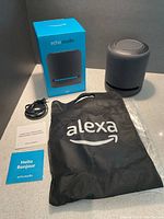 Speaker, original box, power cable, Alexa bag and documentation displayed on counter