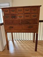 Front view showing all drawers, pull-out desktop and one leg finished in red