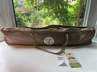 The folded camp cot inside a tan carrying bag with handles, branded with Presidents Choice logo.