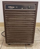 Front view of brown Home Hardware Frost Guard D25 dehumidifier showing the grille, control knob, and indicator lights.