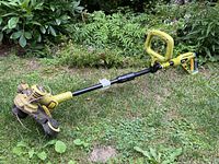 Full view of Radley electric weed whacker showing the yellow handle, elongated black shaft, and yellow protective cutting head area.