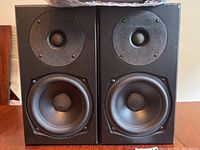 Front view of both black bookshelf speakers showing tweeters and woofers