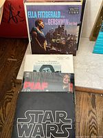 Nine vinyl albums standing upright showing front covers including Ella Fitzgerald sings the Gershwin Song Book and Star Wars soundtrack